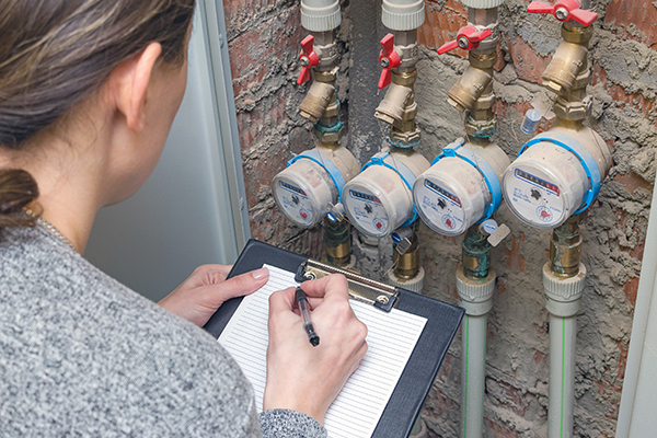 person taking notes of meter readings