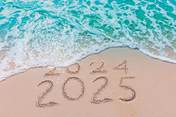 beach with 2024 and 2025 written in the sand