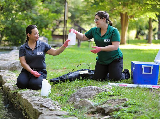people taking water samples at a park