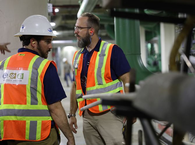Aquiter employees working underground with pips wearing safety vests and equipment