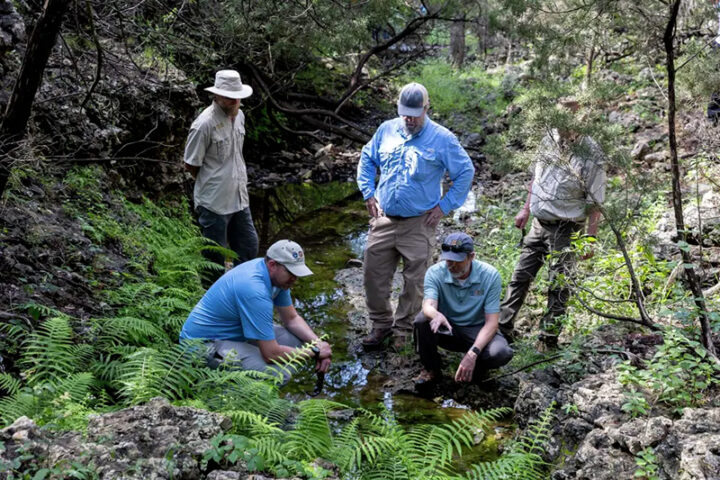 Edwards Aquifer Authority staffers assess a spring at the Dischinger-Brehmer Ranch in Comal County in this file photo.