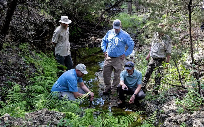 Edwards Aquifer Authority staffers assess a spring at the Dischinger-Brehmer Ranch in Comal County in this file photo.